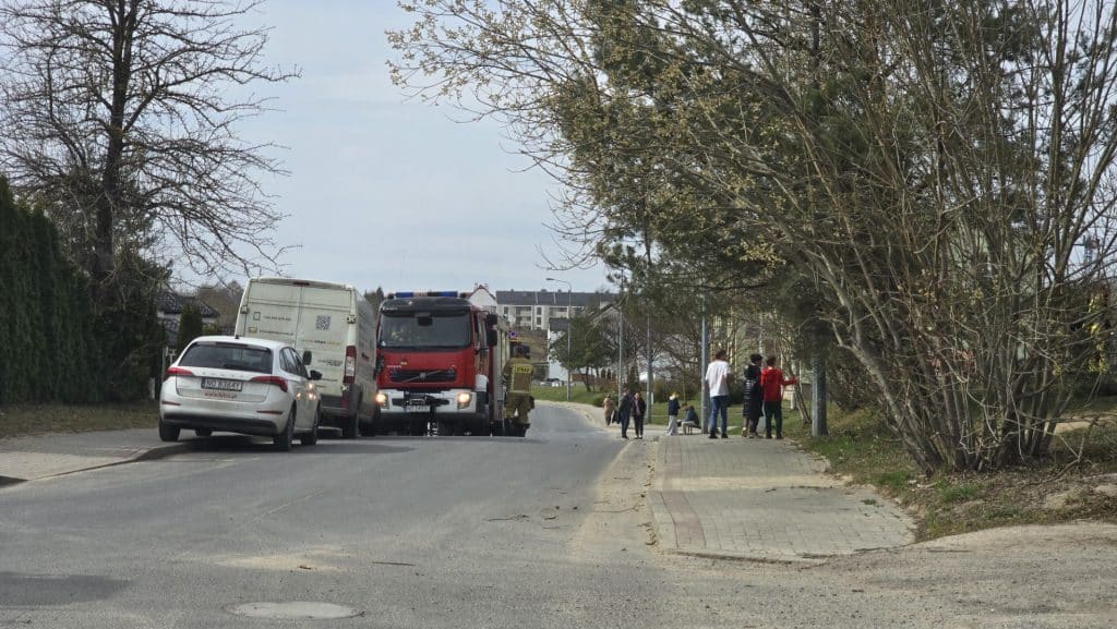 Straż pożarna na osiedlu Likusy podczas nietypowej akcji w Niedzielę Wielkanocną, z wieloma pojazdami i mieszkańcami w tle.