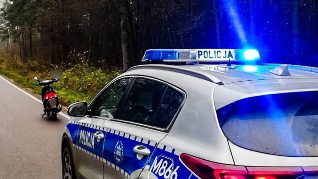 Policja zatrzymuje pijanego kierowcę motoroweru na poboczu drogi w lesistym terenie.