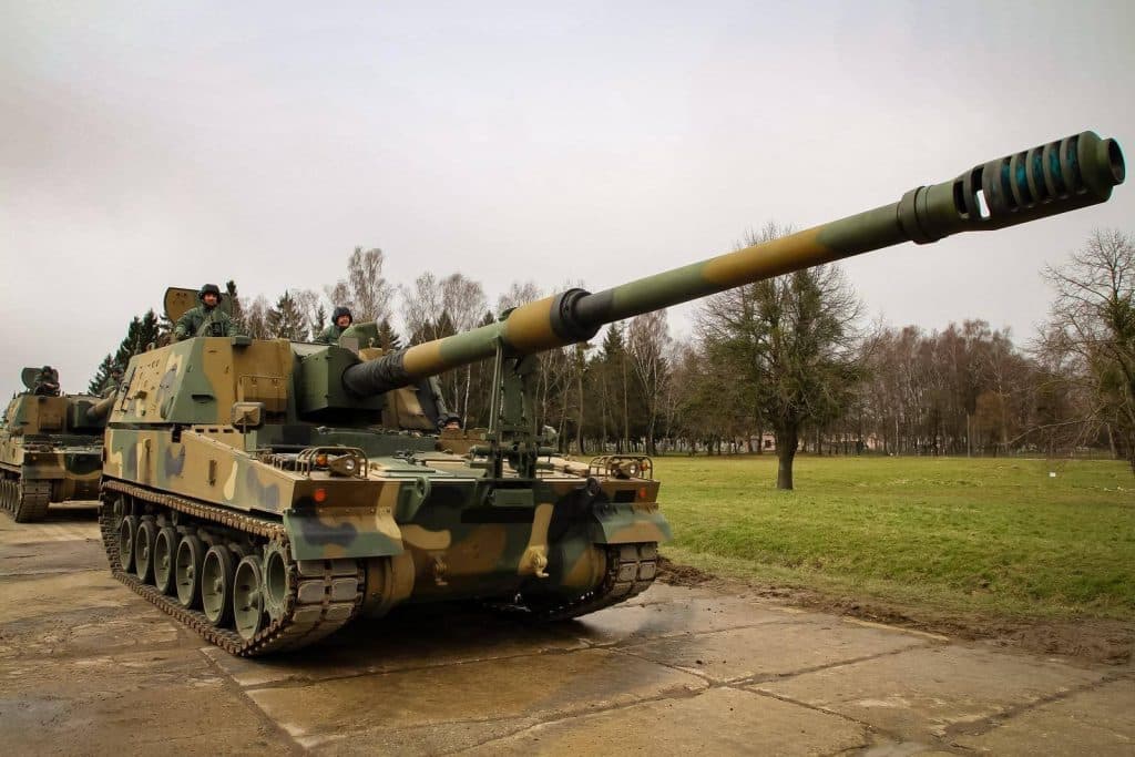 Armatohaubica K9 Thunder na placu, w tle drzewa i szare niebo.