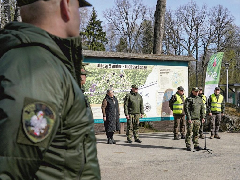 Grupa os&oacute;b sadzi drzewa w Wilczym Szańcu na Mazurach podczas wydarzenia z okazji Światowego Dnia Ziemi.