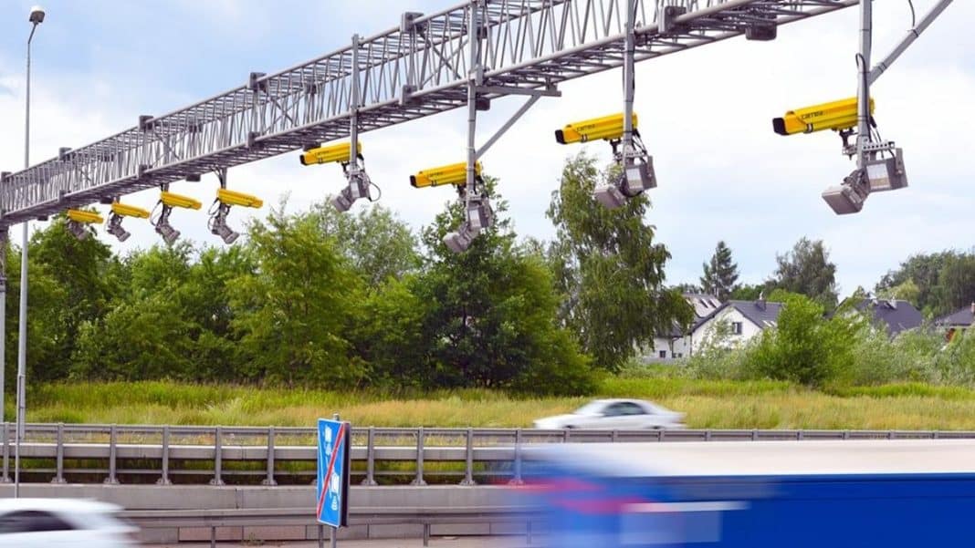 System odcinkowego pomiaru prędkości nad autostradą, z samochodami w ruchu.
