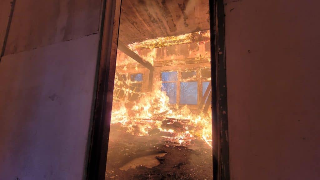 Pożar pustostanu w Elblągu, widok płomieni i zadymionego wnętrza budynku.