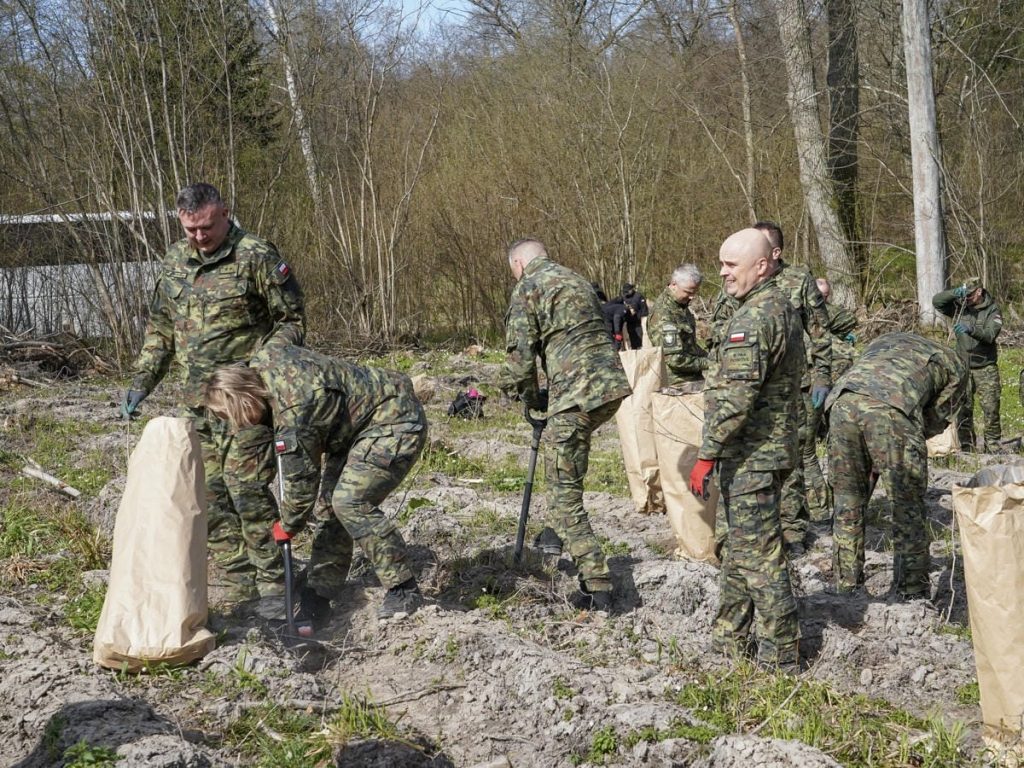 Strażnicy i młodzież sadzą drzewa w lesie na Mazurach podczas akcji z okazji Światowego Dnia Ziemi.