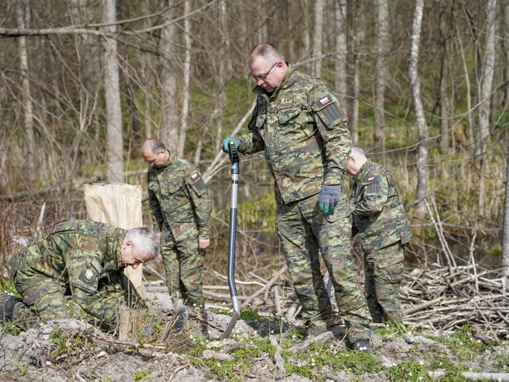 Strażnicy i młodzież sadzą drzewa w lesie na Mazurach podczas akcji z okazji Światowego Dnia Ziemi.