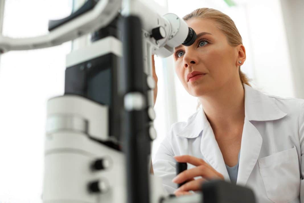 Lekarka badająca oko pacjenta za pomocą tonometru w klinice okulistycznej.