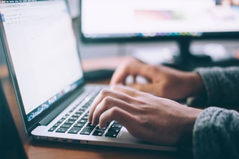 Osoba korzysta z laptopa do porównania ofert ubezpieczeń OC online.