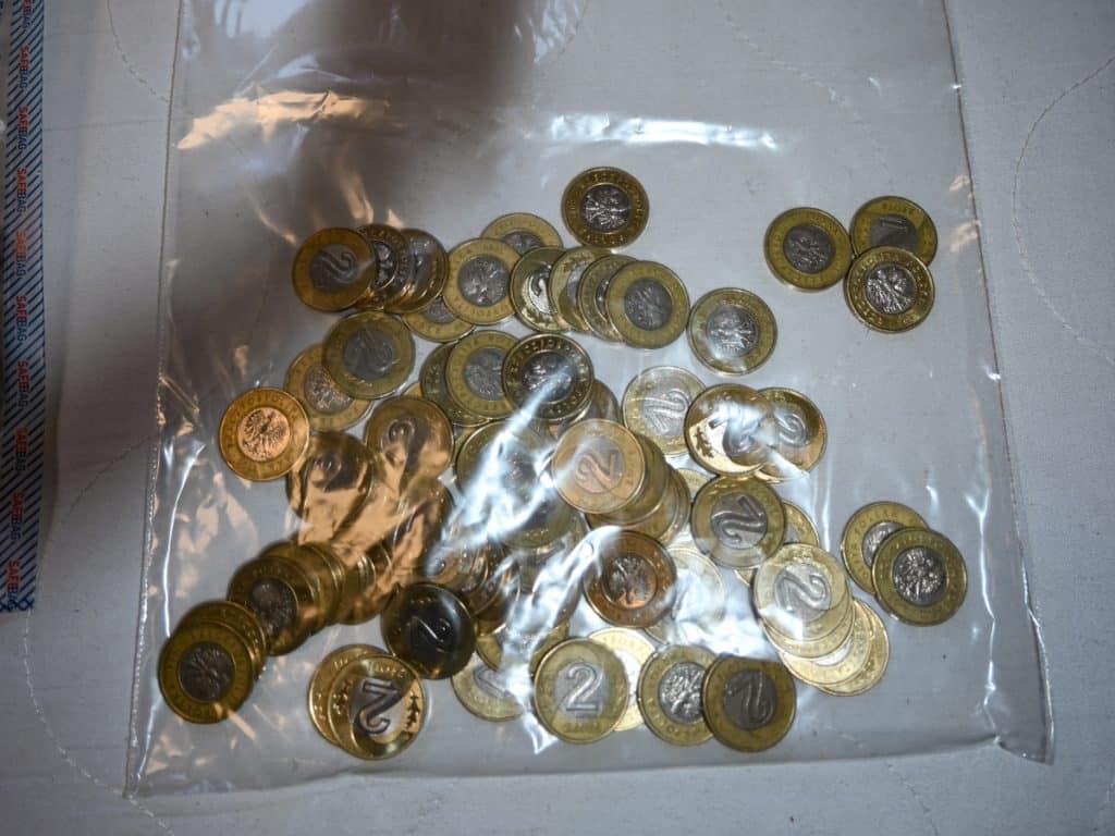 Zbi&oacute;r polskich monet 2 złote w plastikowym woreczku na białym tle.
