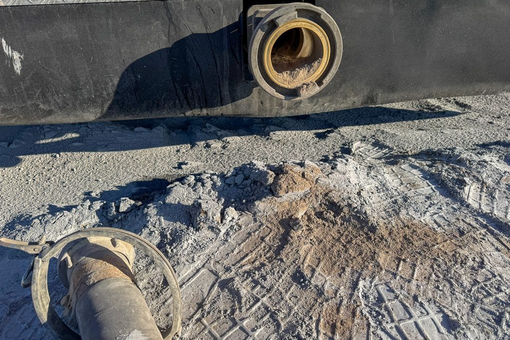 Zdjęcie przedstawia odcinek drogi z widocznym kanałem i śniegiem, z elementami infrastruktury drogowej.