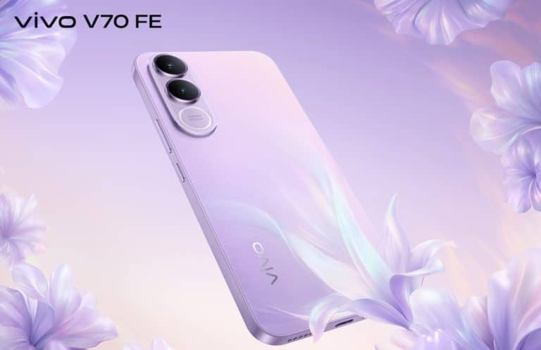 Smartfon vivo V70 FE w pastelowym odcieniu, z potrójnym aparatem i minimalistycznym designem, otoczony kwiatami.