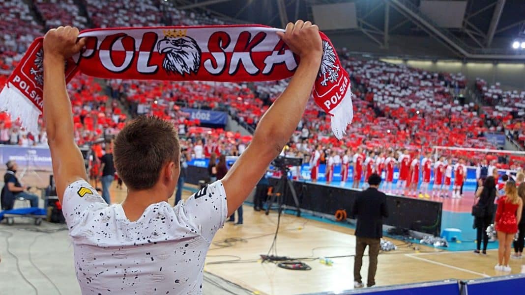 Młody kibic trzyma szalik z napisem 'Polska' podczas meczu siatk&oacute;wki w hali Urania w Olsztynie.