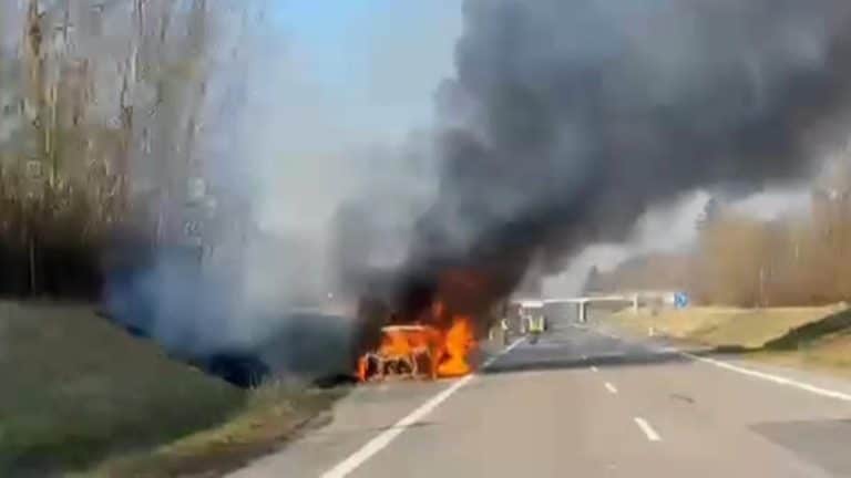 Samoch&oacute;d marki Audi płonie na drodze ekspresowej, unosząc duże kłęby dymu.