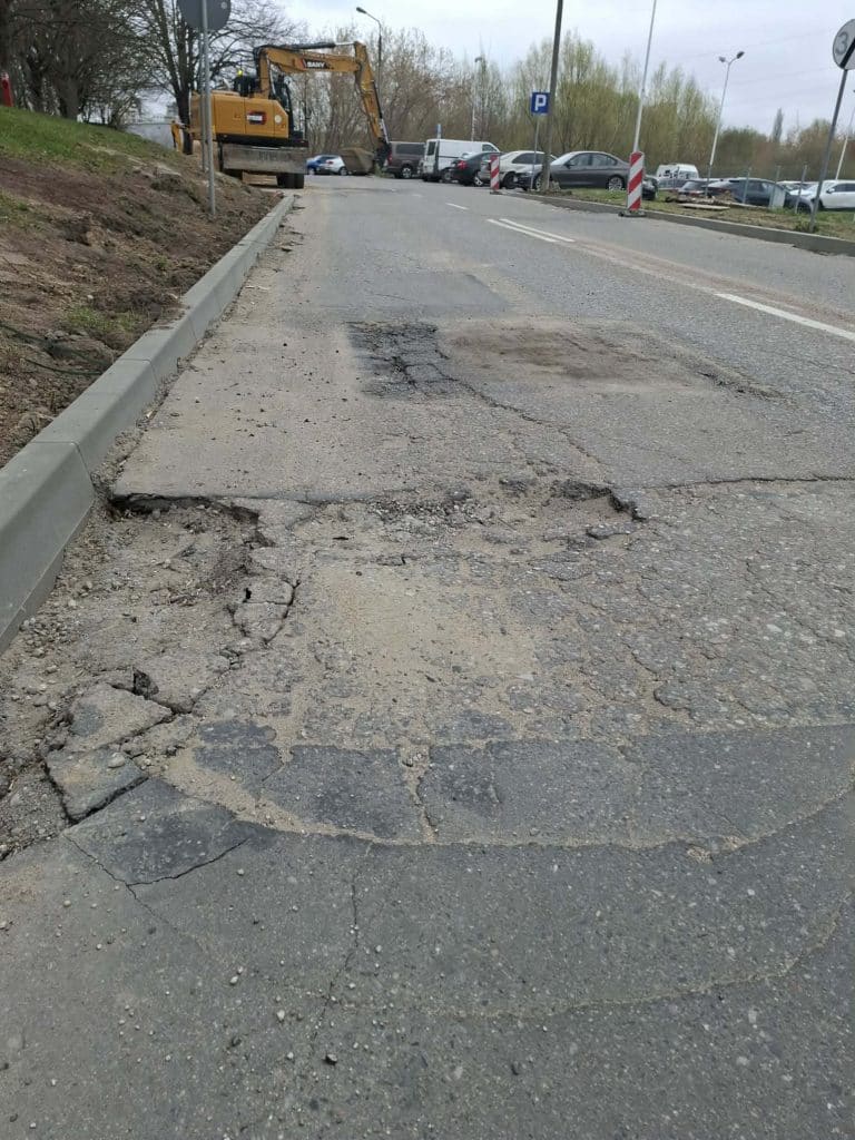 Rozpoczęcie remontu drogi na osiedlu Mleczna w Olsztynie, widok na uszkodzoną nawierzchnię i maszyny budowlane.