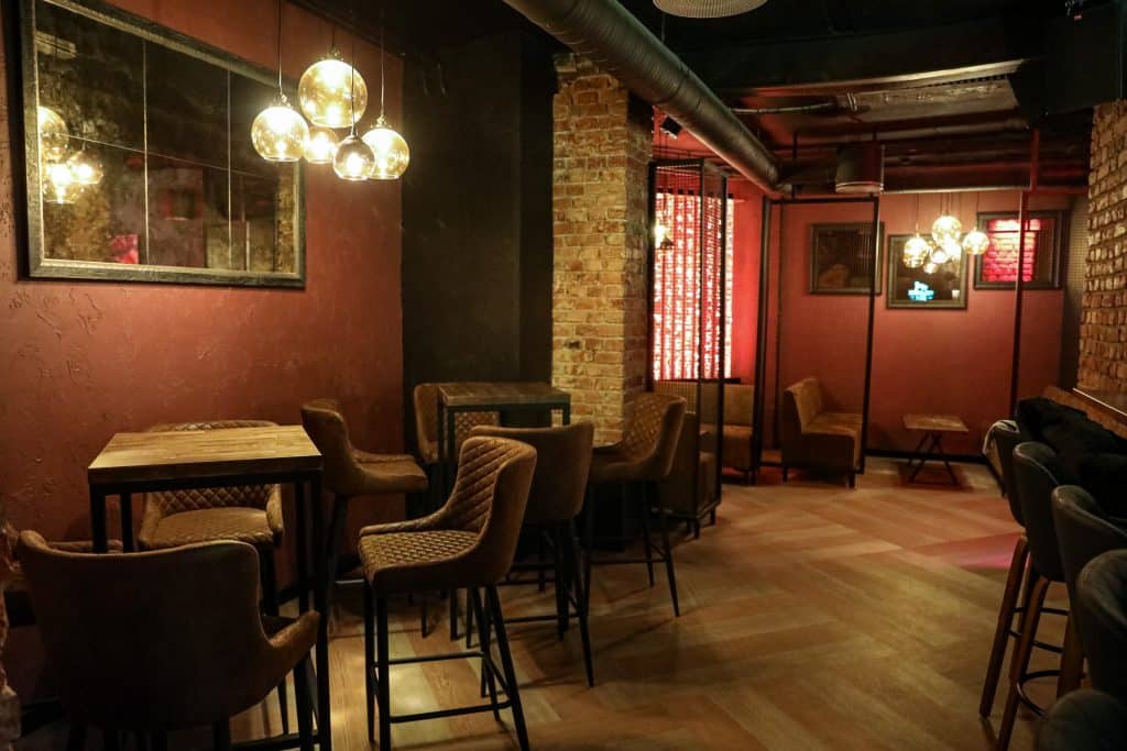 Wnętrze nowego klubu Dyskoteka Music Bar w Olsztynie, z ciepłym oświetleniem i wygodnymi siedzeniami.