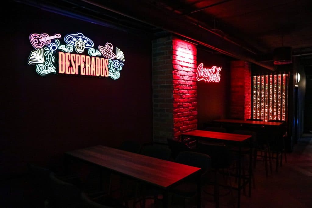 Wnętrze nowego klubu Dyskoteka Music Bar w Olsztynie z neonowymi napisami i ciemnym wystrojem.