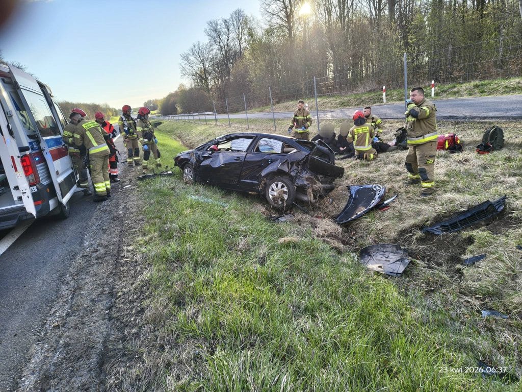 Służby ratunkowe na miejscu wypadku samochodowego na drodze S22, samoch&oacute;d dachował w rowie.