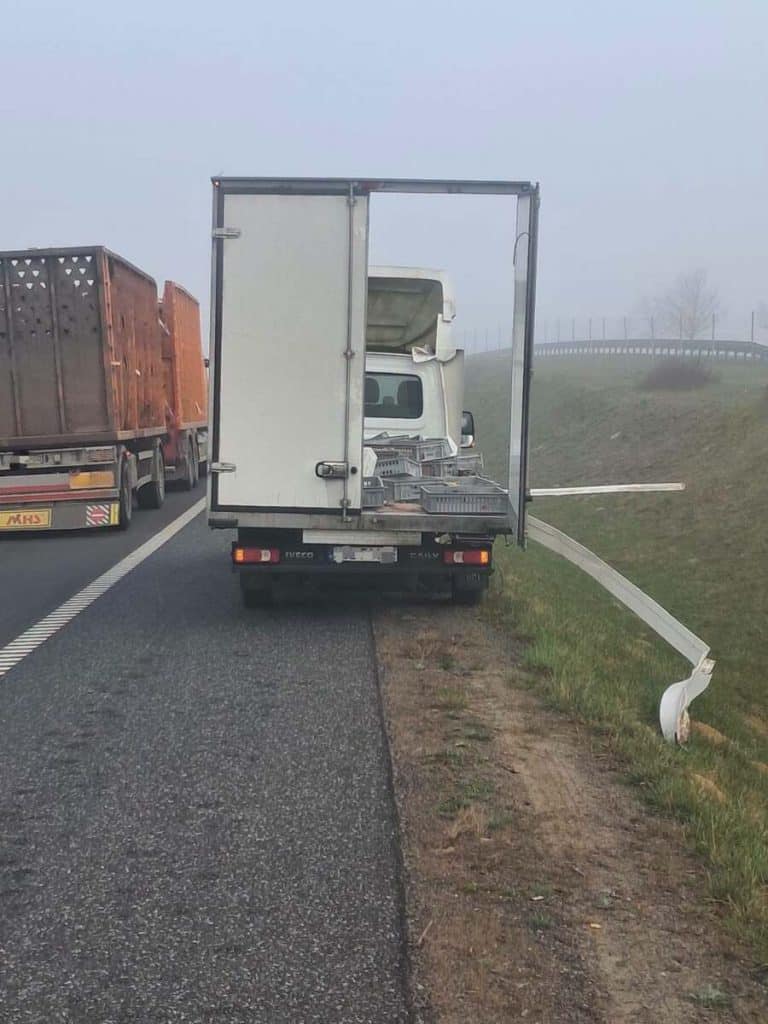 Samoch&oacute;d dostawczy z uszkodzonym tyłem i rozsypanym ładunkiem na drodze S7.