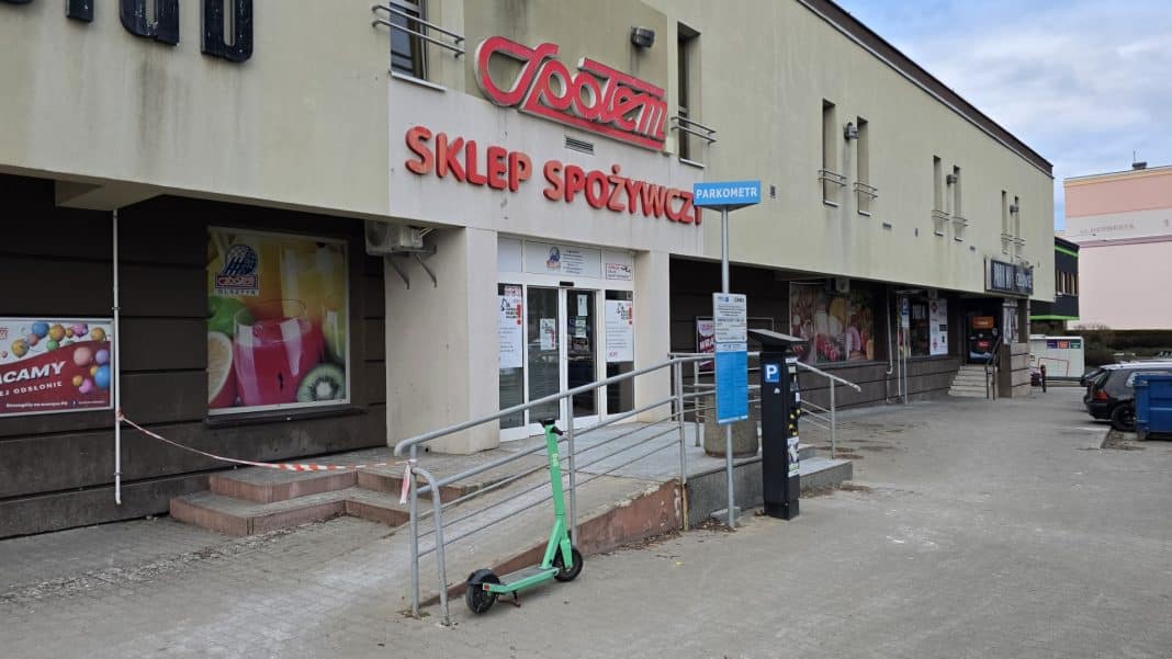Zamknięte wejście do sklepu Społem na ul. Wilczyńskiego w Olsztynie, na drzwiach widoczny komunikat o zamknięciu.