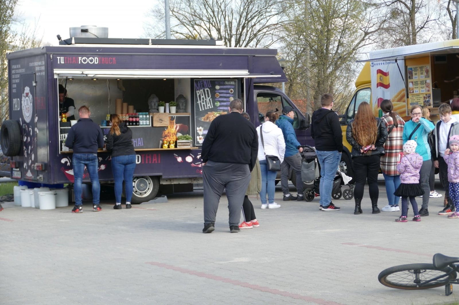 Ludzie stoją przed food truckiem na festiwalu w Olsztynie, czekając na jedzenie i napoje.