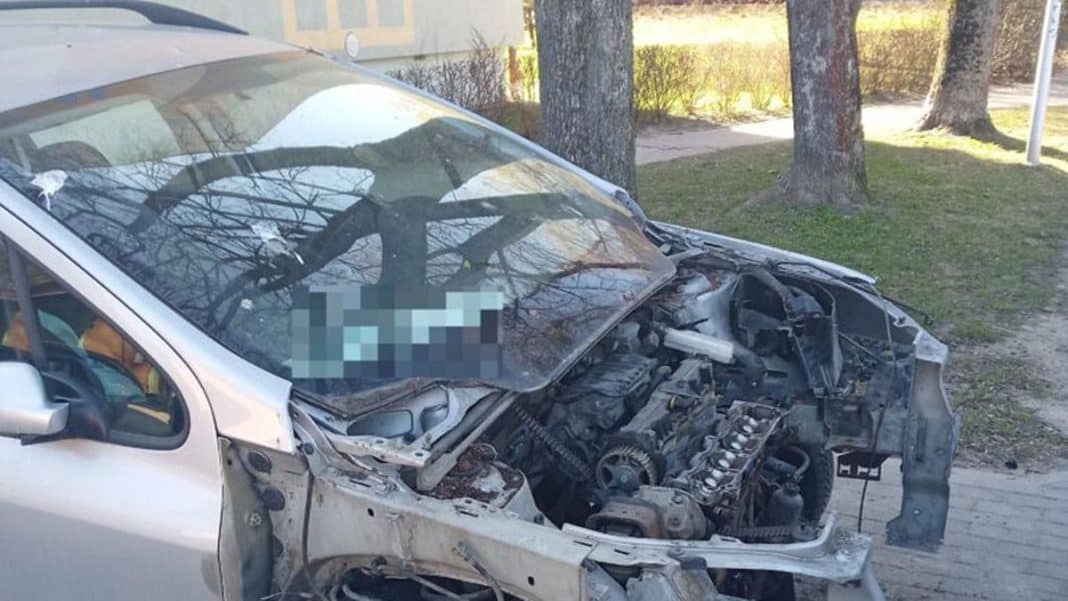 Uszkodzony samoch&oacute;d z widocznymi uszkodzeniami silnika i karoserii na ulicy w Olsztynie.