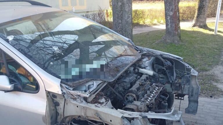 Uszkodzony samoch&oacute;d z widocznymi uszkodzeniami silnika i karoserii na ulicy w Olsztynie.