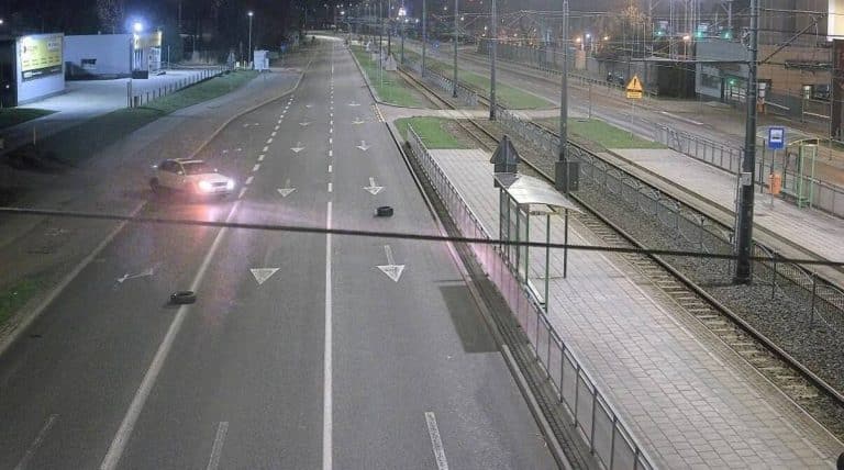 Rozrzucone opony na środku ulicy w Elblągu w nocy, tworzące zagrożenie dla kierowc&oacute;w.