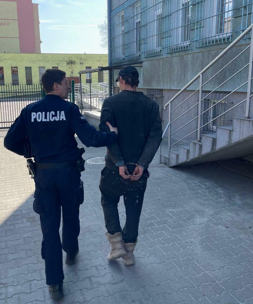 Policjant zatrzymuje poszukiwanego mężczyznę na ulicy w Olsztynie.