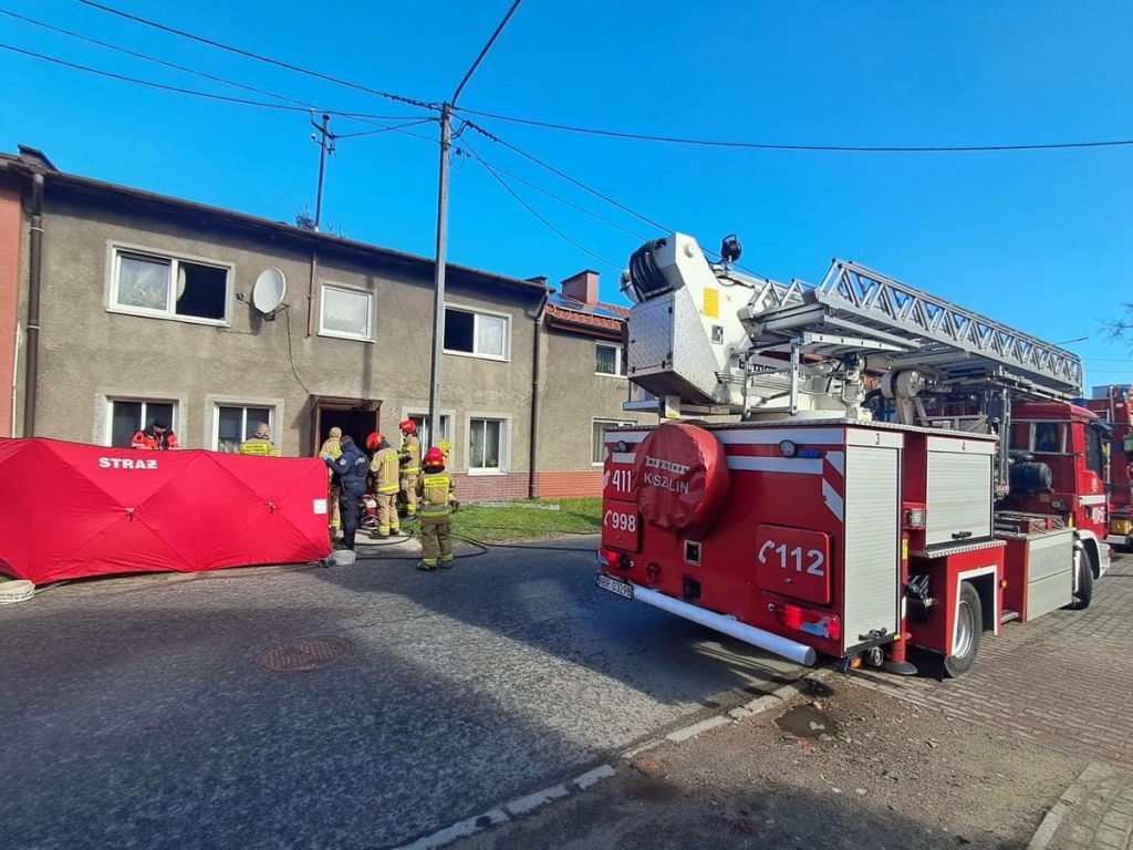 Strażacy wejści do mieszkania podczas akcji ratunkowej w niedzielny poranek.