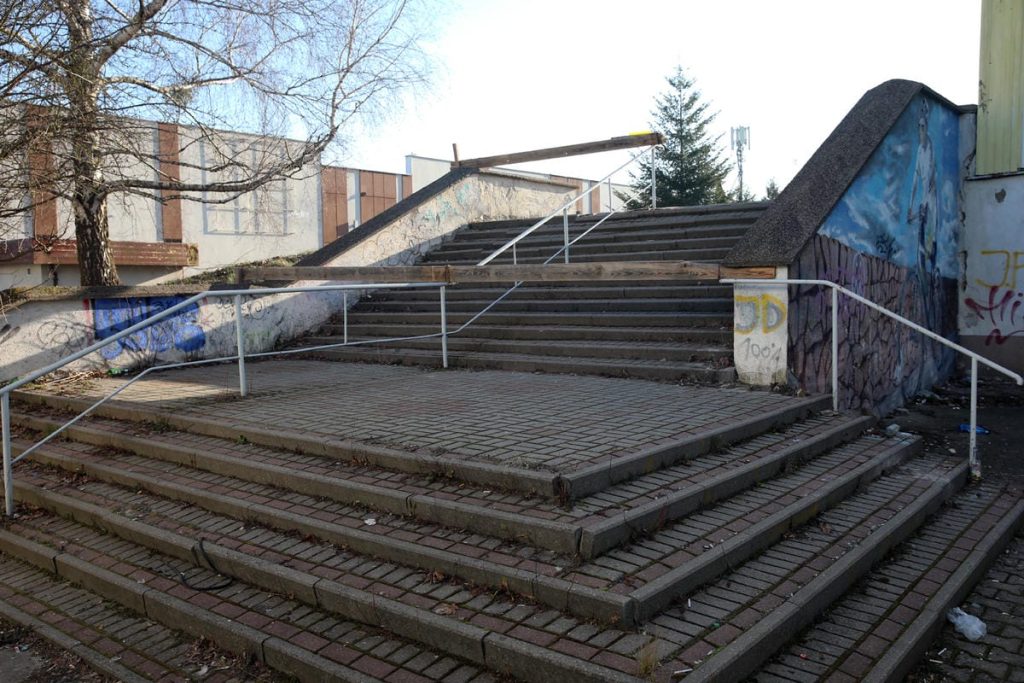 Schody prowadzące do nieistniejącego już pawilonu przy Hali Urania w Olsztynie, z graffiti na ścianach.