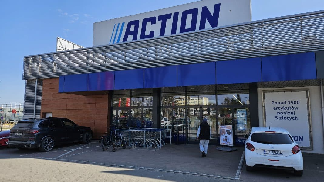 Widok z zewnątrz sklepu Action z oznaczeniem ograniczeń wiekowych przy p&oacute;łkach.