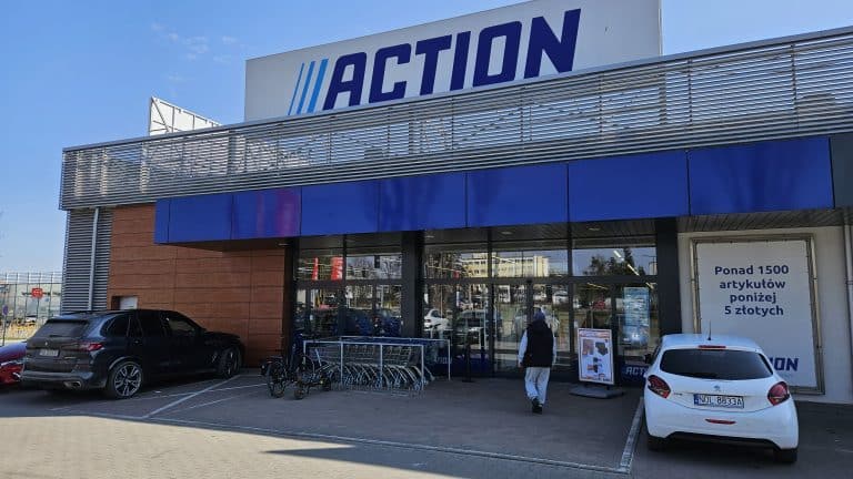 Widok z zewnątrz sklepu Action z oznaczeniem ograniczeń wiekowych przy p&oacute;łkach.