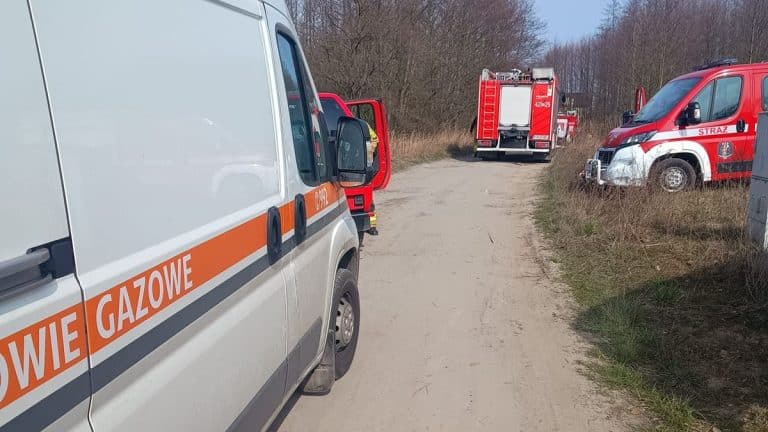 Działania służb ratunkowych przy uszkodzonym gazociągu pod Olsztynem, widoczne pojazdy na drodze.