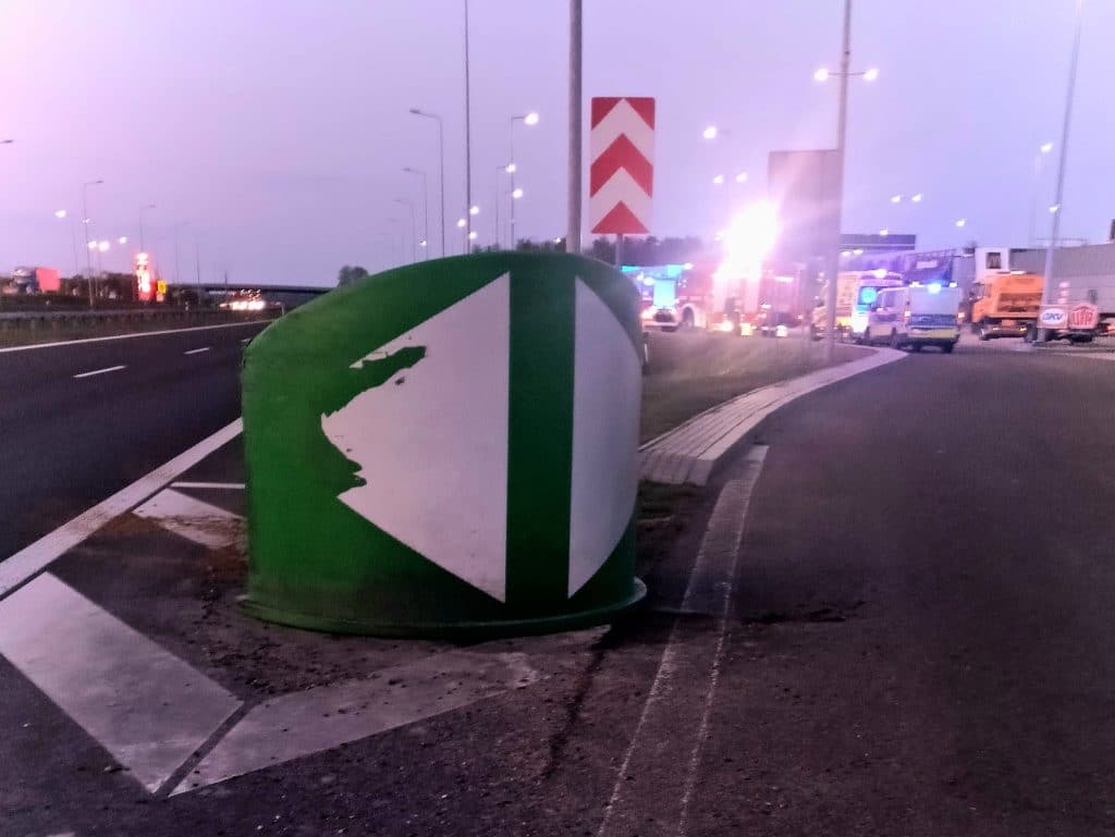 Widok na uszkodzony barierki drogowe i pojazdy na drodze S7 po dachowaniu samochodu.