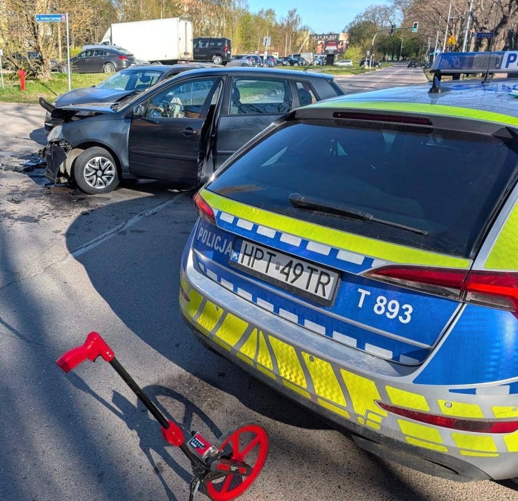 Wypadek na skrzyżowaniu w Ostr&oacute;dzie, uszkodzone samochody i radiow&oacute;z na miejscu zdarzenia.