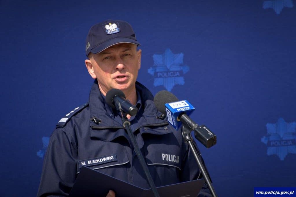 Policjant w uniformie podczas konferencji prasowej przed nową komendą w Ostr&oacute;dzie.