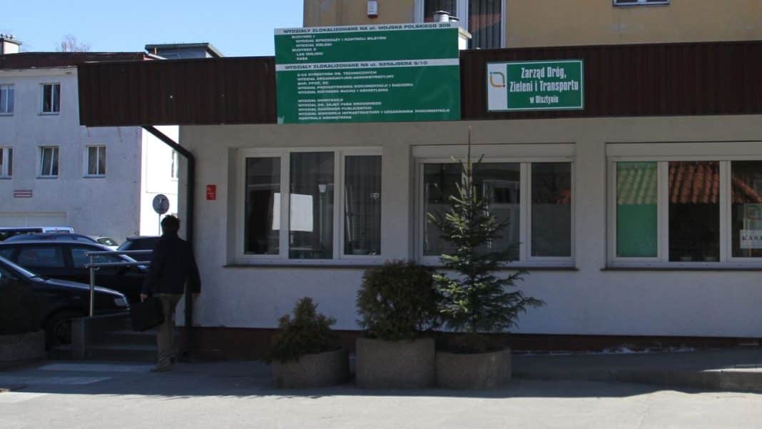Budynek Zarządu Dr&oacute;g, Zieleni i Transportu w Olsztynie z zielonymi tablicami informacyjnymi.