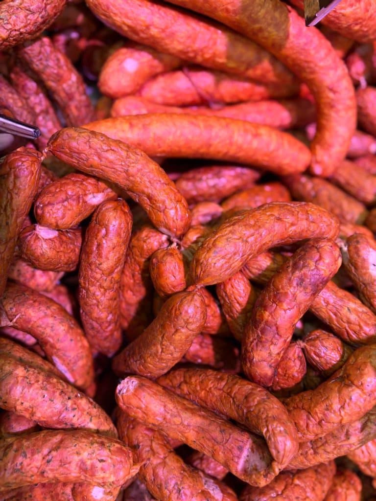 Zbliżenie na kiełbaski i mięsa na grilla w sklepie spożywczym.