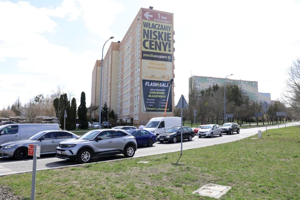 Wielki billboard na budynku w Olsztynie promujący platformę Flashsale.pl i lokalne okazje.
