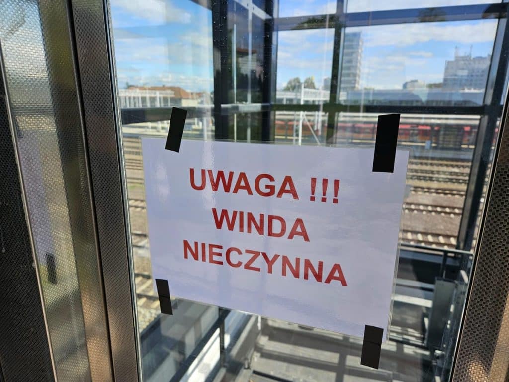 Zamknięte przejście pod torami na dworcu Olsztyn Gł&oacute;wny z informacją o nieczynnej windzie.