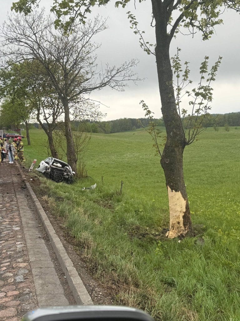 Wrak samochodu po uderzeniu w drzewo na Mazurach, uszkodzona przednia część pojazdu, pogięta blacha.