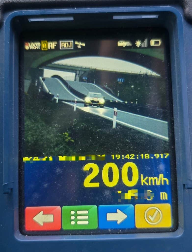 Zdjęcie urządzenia pomiaru prędkości z wyświetloną wartością 200 km/h, na tle obwodnicy.