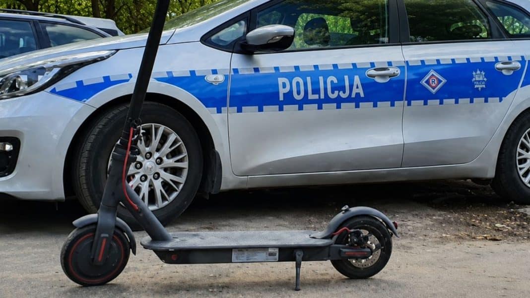 Policja w miejscowości Korsze, obok hulajnoga elektryczna na chodniku, w tle radiow&oacute;z policyjny.