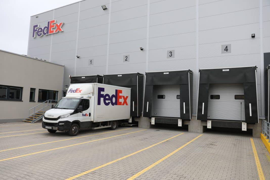 Nowe centrum logistyczne FedEx w Olsztynie, z naczepami i samochodem przy wejściu.