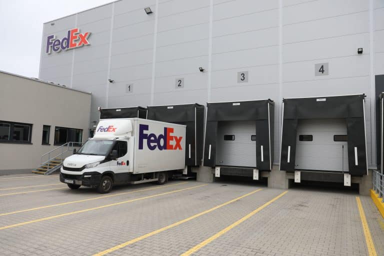 Nowe centrum logistyczne FedEx w Olsztynie, z naczepami i samochodem przy wejściu.