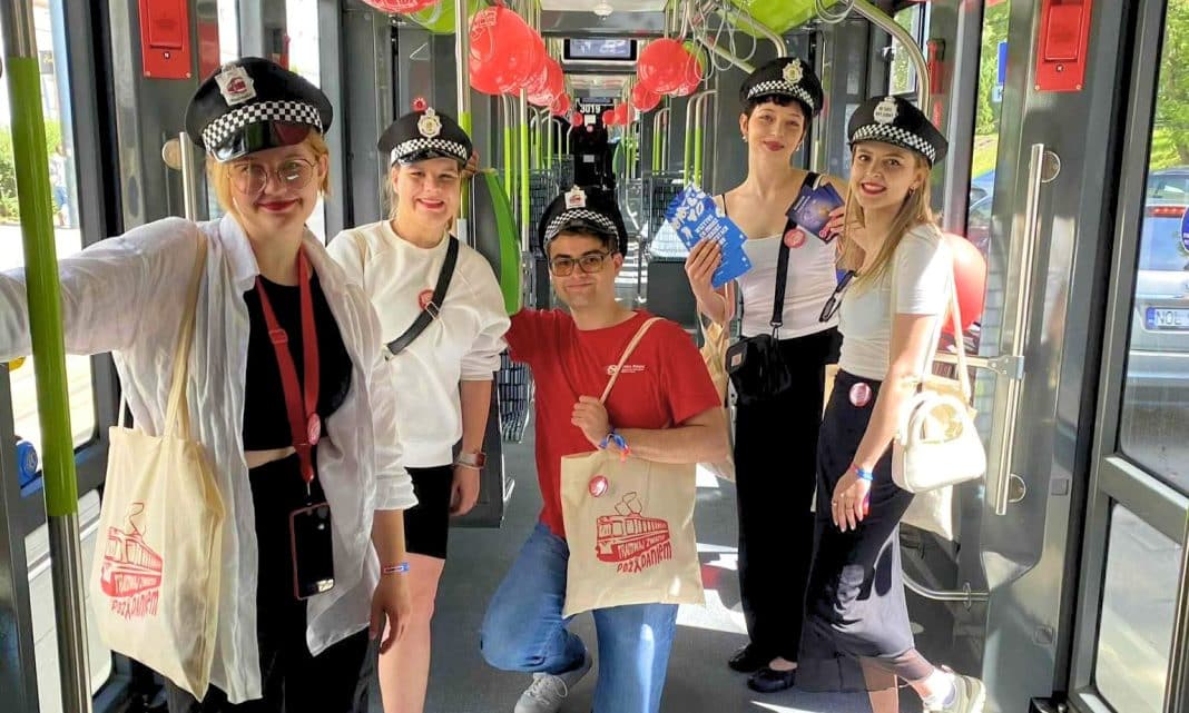 Grupa edukatorów w policjantkach i studentów medycyny w tramwaju podczas akcji edukacyjnej o HIV.