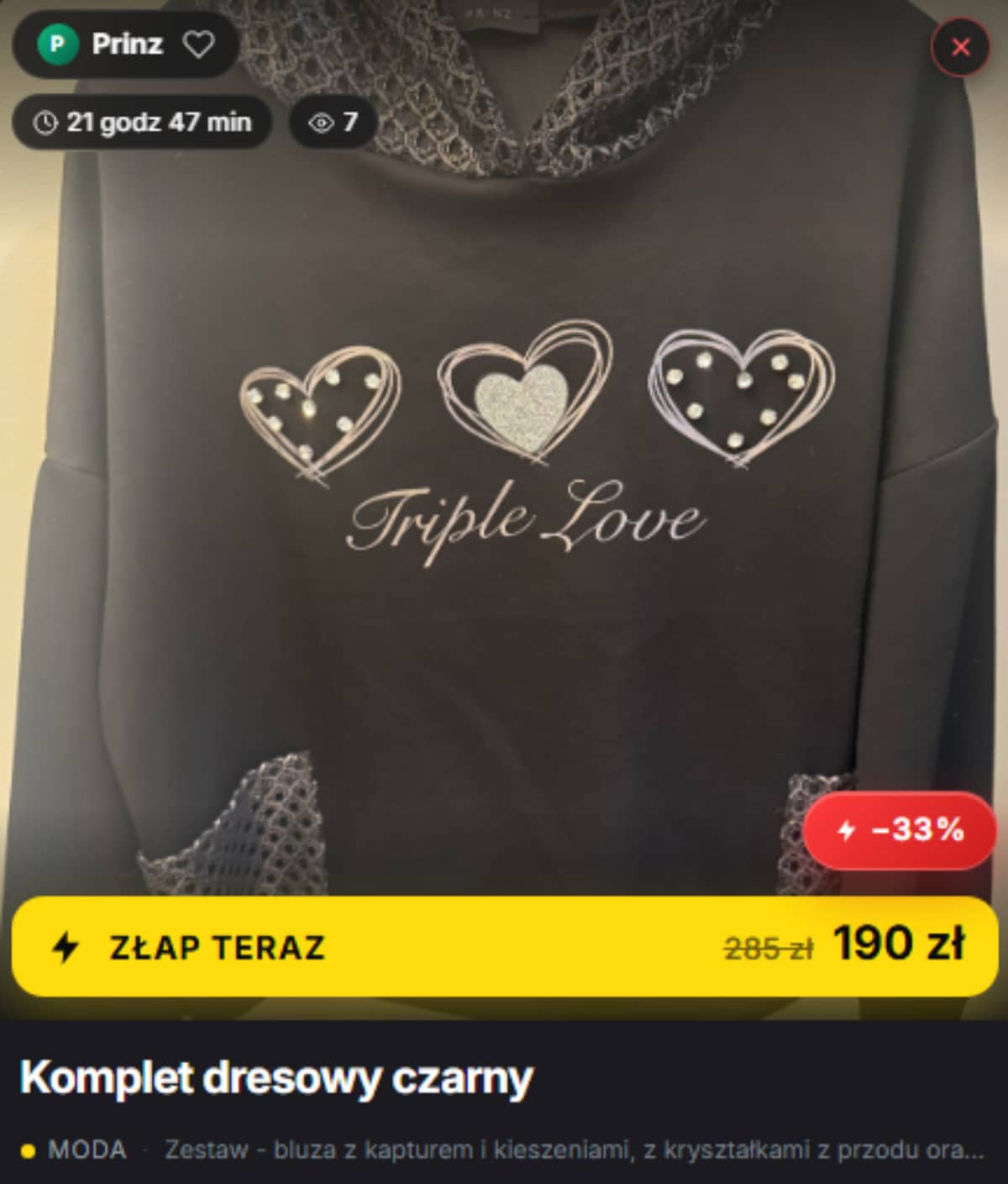 Zdjęcie czarnej bluzki z trzema serduszkami i napisem Triple Love, na tle jasnej powierzchni.