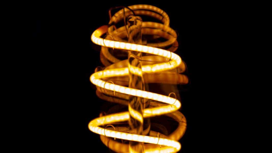 Oświetlenie dekoracyjne w formie spiralnej lampy na tle ciemnego tła.