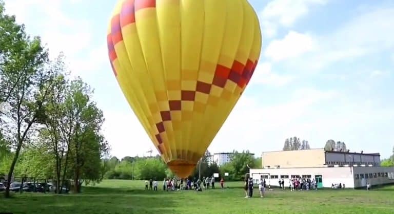 Balon pasażerski ląduje awaryjnie na terenie szkoły w Olsztynie, wokół ludzie i służby ratunkowe.
