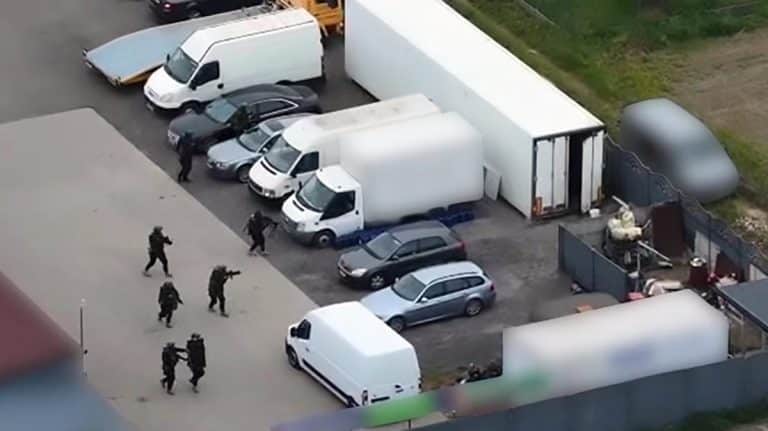 Akcja służb w miejscu zatrzymania, widoczne samochody i funkcjonariusze w akcji.