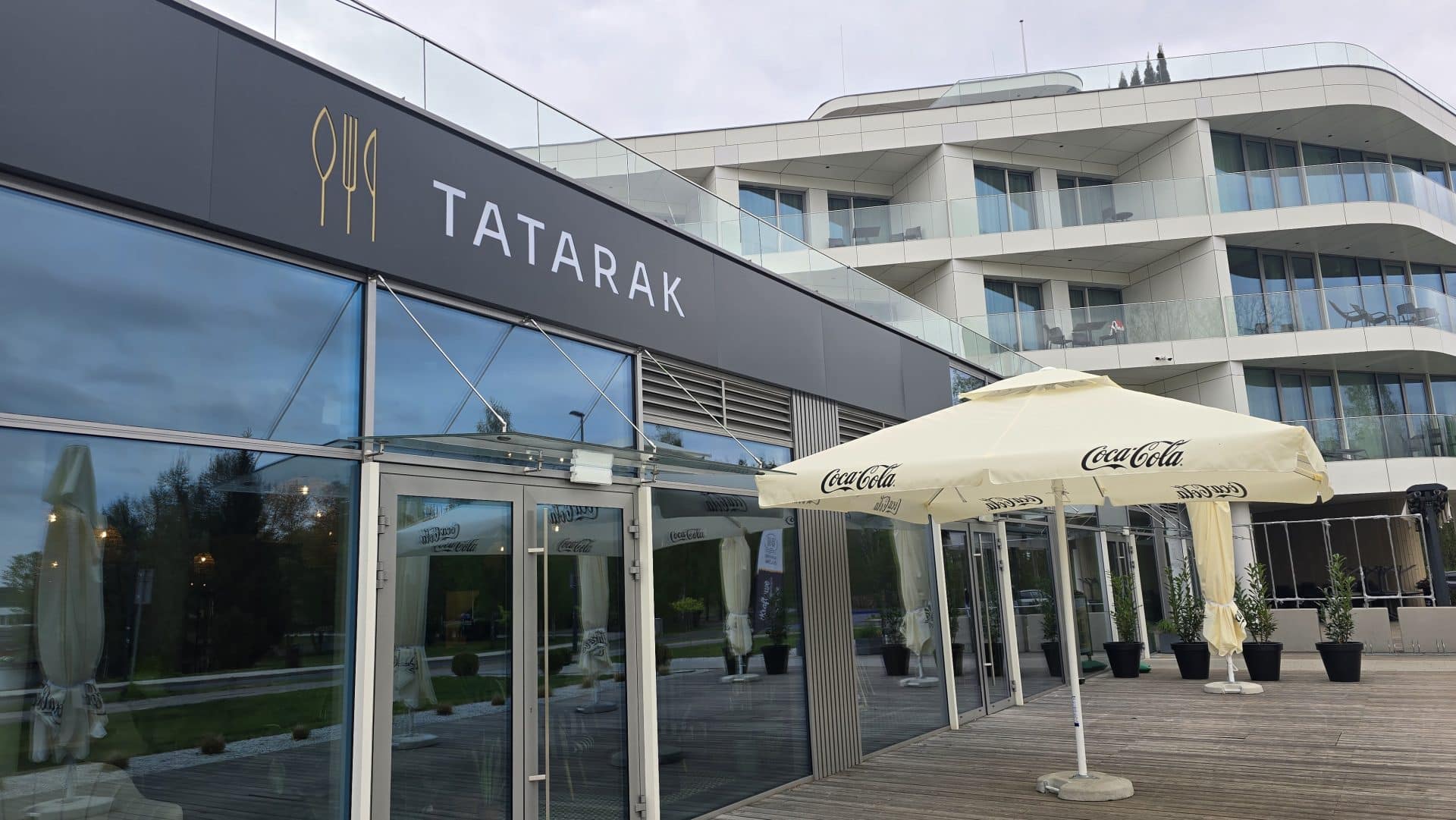 Nowa restauracja Tatarak nad Jeziorem Ukiel, widok na wejście i taras z parasolami.
