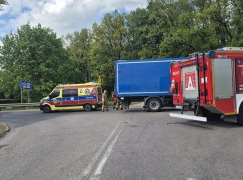 Wypadek na skrzyżowaniu z udziałem samochodu osobowego i ciężar&oacute;wki, służby ratunkowe na miejscu.
